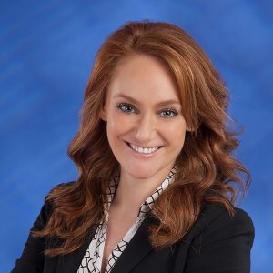 Professional portrait of Searle Starter, a team member at Coast Fiduciary, smiling in a business setting, highlighting expertise in financial planning and client service.
